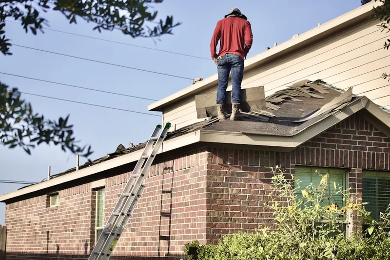 Professional roofer working on a residential roof in Monroe